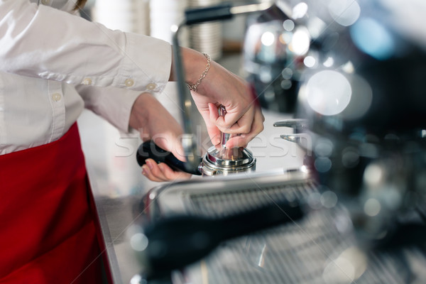 Waiter preparing espresso at an automatic coffee machine Stock photo © Kzenon