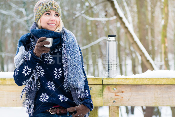 Woman freezing on a cold winter day warming herself up with hot  Stock photo © Kzenon