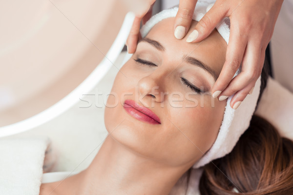 Relaxed woman smiling under the benefits of anti-aging facial massage Stock photo © Kzenon