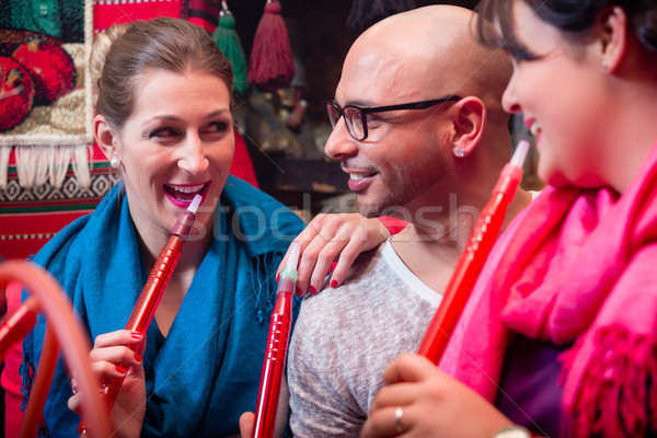 Women and man enjoying recreational shisha in hookah lounge Stock photo © Kzenon