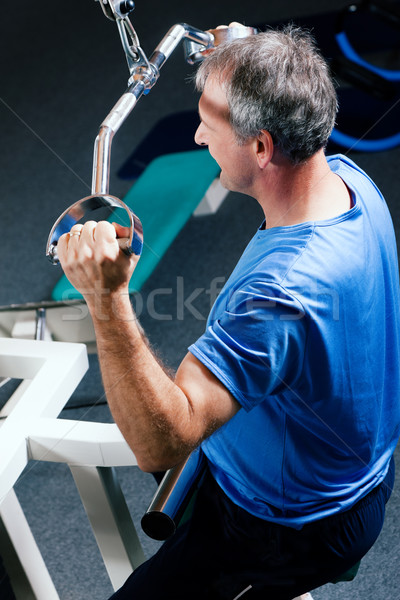 Senior man exercising in gym Stock photo © Kzenon