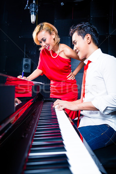 Stock photo: Asian professional musician recording song in studio