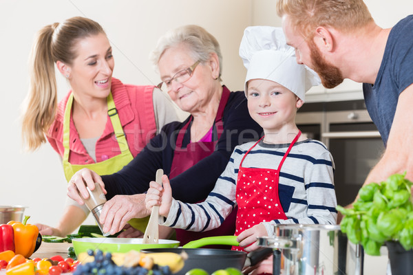 Family cooking in multigenerational household with son, mother,  Stock photo © Kzenon