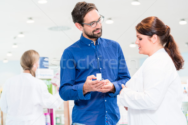 Pharmacist or drug store sales woman advising customer Stock photo © Kzenon