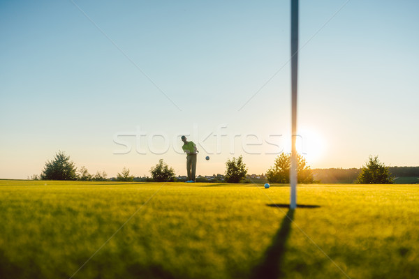 Silhouette of a male player hitting a long shot on the putting g Stock photo © Kzenon