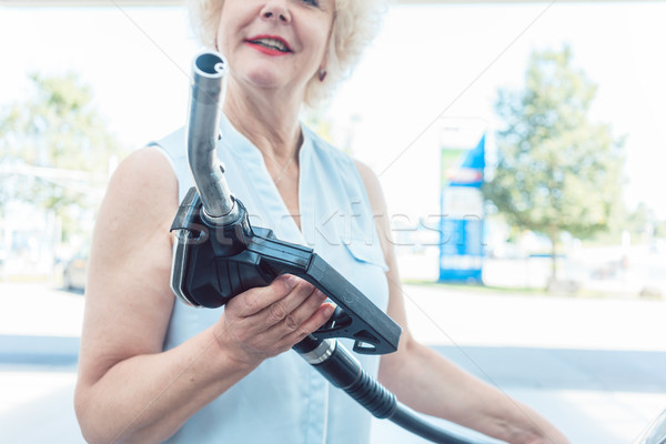 Close-up of the hand of a senior female driver holding the gas dispenser Stock photo © Kzenon