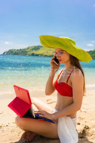 Fashionable young woman talking on mobile phone on the beach Stock photo © Kzenon