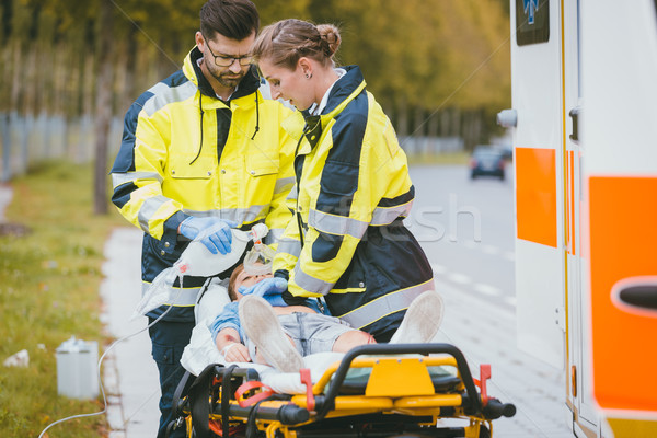 Emergency doctor giving oxygen to accident victim Stock photo © Kzenon