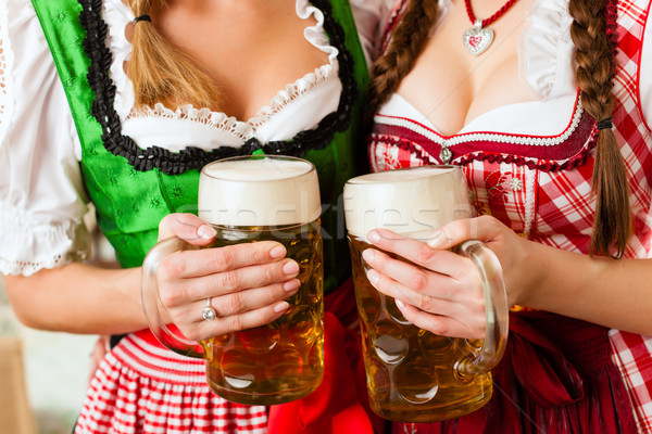 Two young women in traditional Bavarian Tracht in restaurant or pub Stock photo © Kzenon