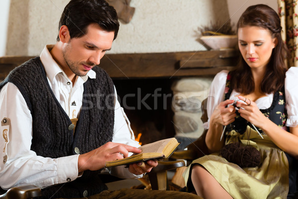 Young couple in mountain hut at fire place Stock photo © Kzenon