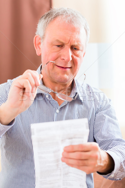 Stock photo: Senior reading with presbyopia package insert