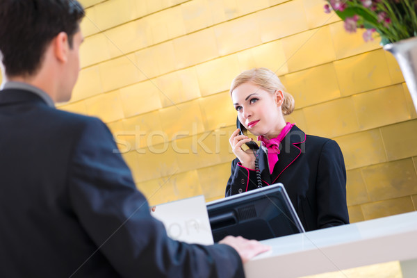 Stock photo: Hotel receptionist with phone and guest