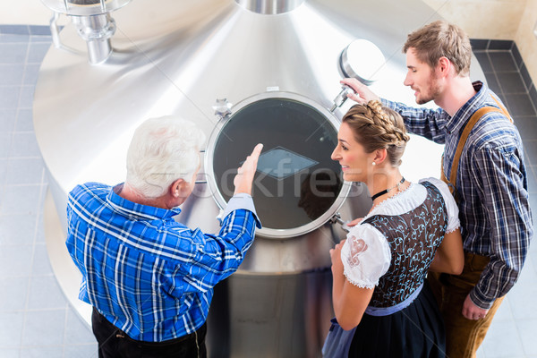 Brewer and couple in beer brewery guided tour Stock photo © Kzenon