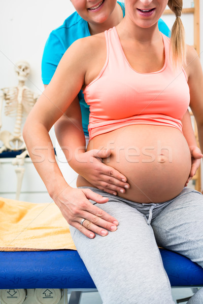 Pregnant woman with physical therapist sitting on couch Stock photo © Kzenon