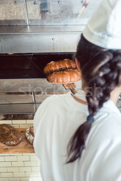 麵包師傅 新鮮 麵包 鏟 出 烤箱 商業照片 © Kzenon