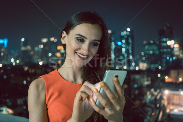 Woman using phone for social media in urban setting Stock photo © Kzenon