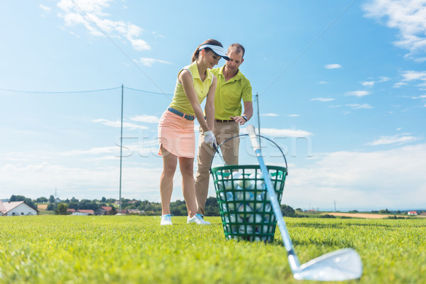 Cheerful young woman learning the correct grip and move for using the golf club Stock photo © Kzenon