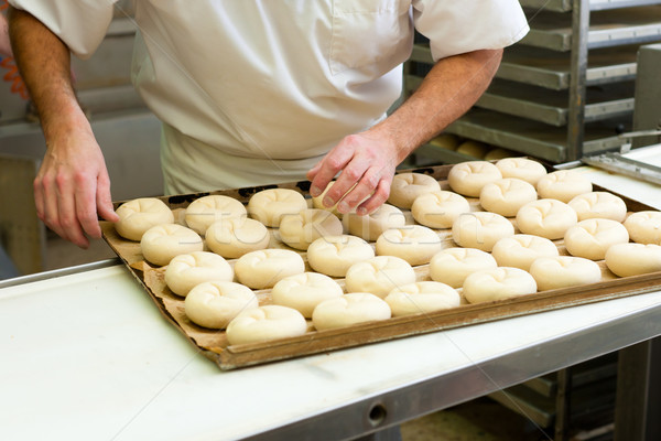 Male baker baking bread rolls Stock photo © Kzenon
