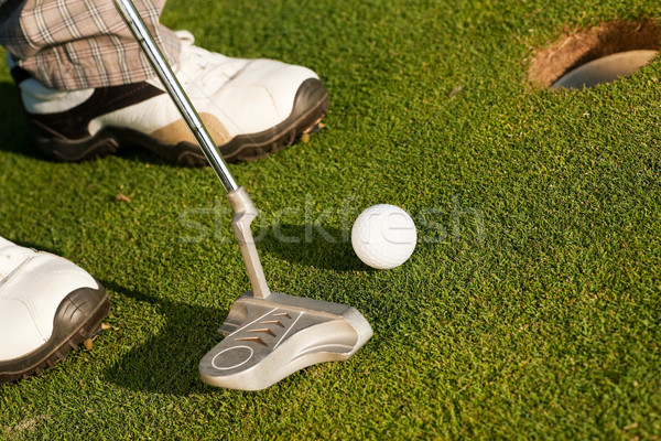 Putting golf ball in cup Stock photo © Kzenon