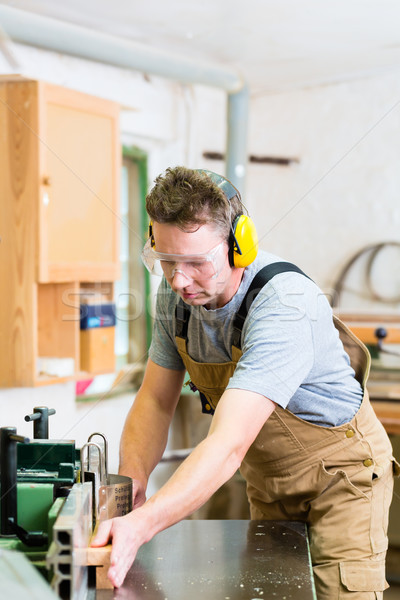 Stock photo: Carpenter using electric saw in carpentry