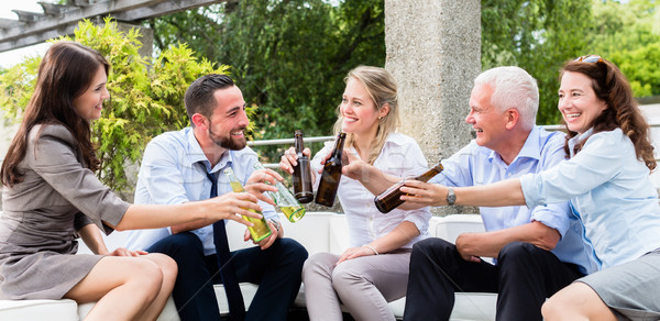 Office colleagues drinking beer after work Stock photo © Kzenon