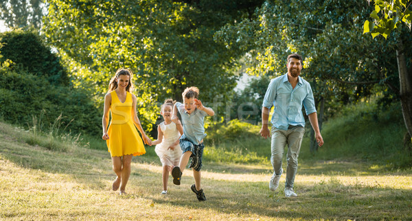 Active young parents with a healthy lifestyle running together w Stock photo © Kzenon
