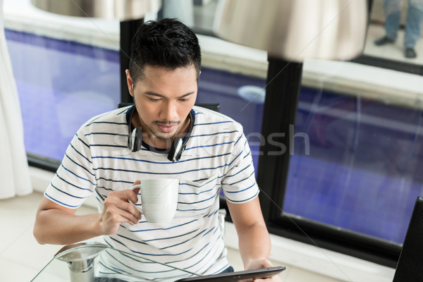 Asian man drinking coffee in his home Stock photo © Kzenon