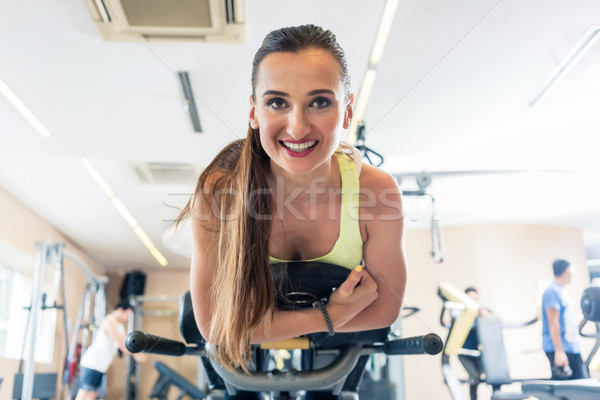 Low-angle view portrait of a cheerful woman during cycling workout Stock photo © Kzenon