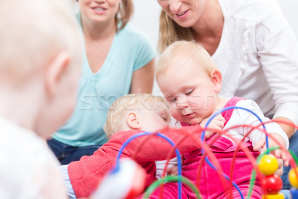 Stock photo: Portrait of a cute blond baby girl playing with colorful toys