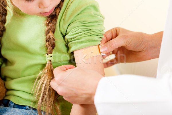 doctor applying bandage - Pediatrician Stock photo © Kzenon