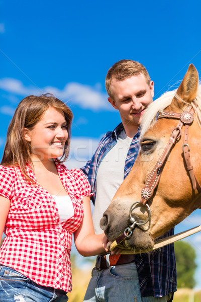 Couple petting horse on pony farm Stock photo © Kzenon