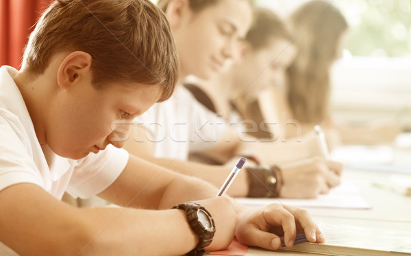 Students or pupils writing test in school being concentrated Stock photo © Kzenon