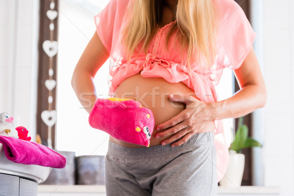 Pregnant woman cleaning baby belly with washcloth Stock photo © Kzenon