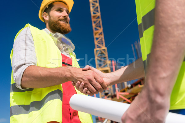Derűs munkás kezet fog építész építőmunkás kézmozdulat Stock fotó © Kzenon