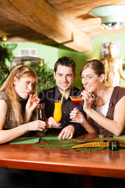 Young people drinking cocktails in bar or restaurant Stock photo © Kzenon