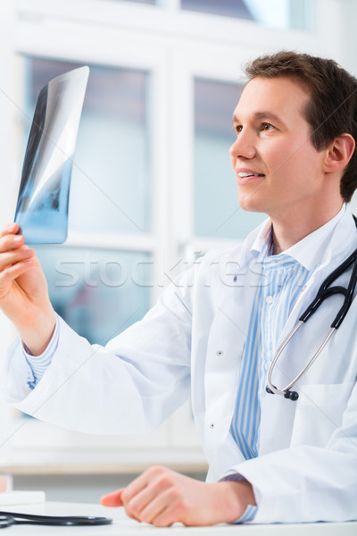 Competent doctor analyzes x-ray image Stock photo © Kzenon