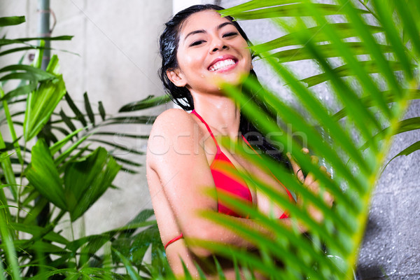 Asian woman using shower in tropical garden Stock photo © Kzenon