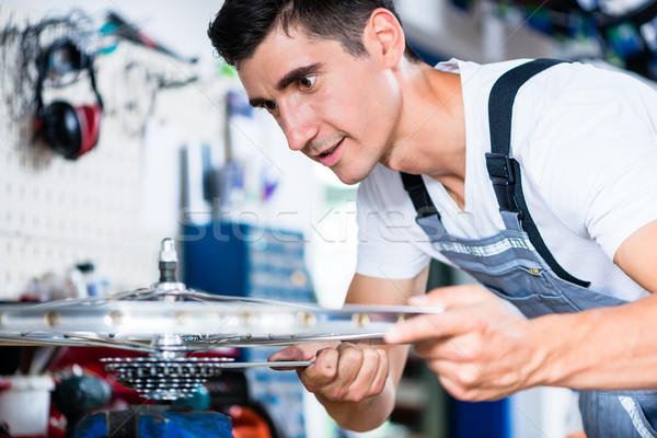 Bicycle mechanic working in his bike workshop Stock photo © Kzenon