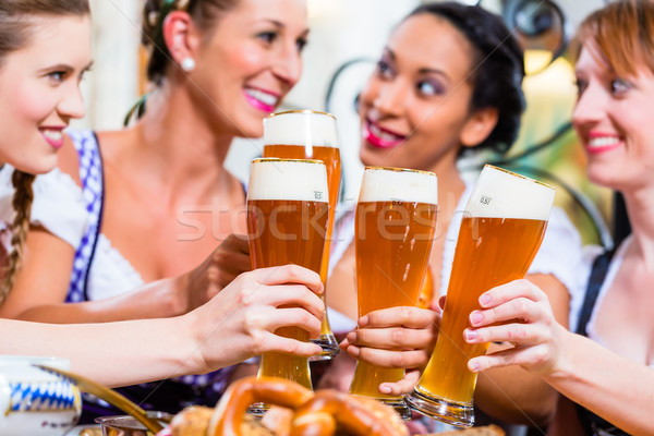 Girls toasting with wheat beer in Bavarian pub Stock photo © Kzenon