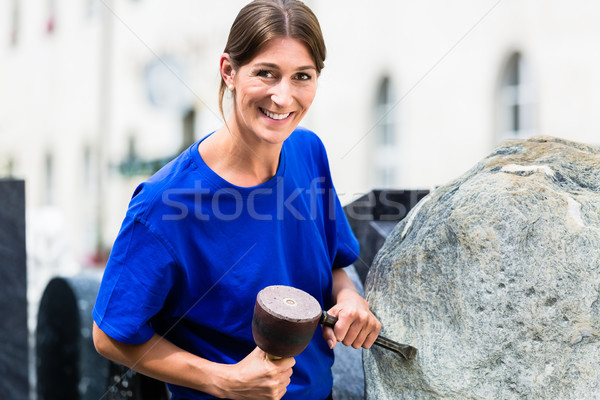 Stonemason working on boulder with sledgehammer and iron Stock photo © Kzenon