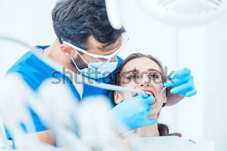 Young woman during painless oral treatment in a modern dental office Stock photo © Kzenon