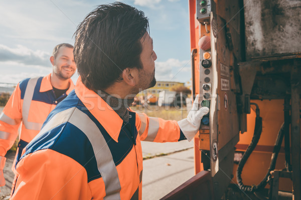 Two garbagemen working together on emptying dustbins  Stock photo © Kzenon