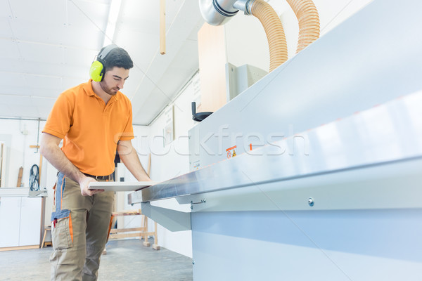 Carpenter in furniture factory working on veneer machine Stock photo © Kzenon