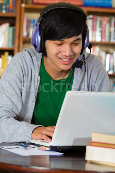 Hombre biblioteca portátil auriculares estudiante jóvenes Foto stock © Kzenon