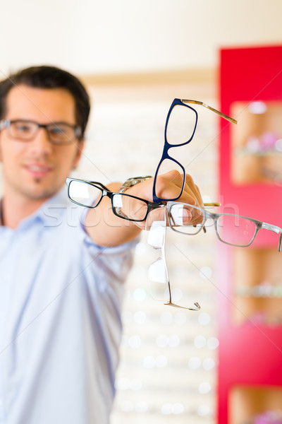 Young man at optician with glasses Stock photo © Kzenon