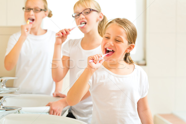Girls tooth brushing in the bath room Stock photo © Kzenon