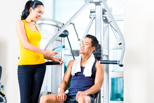 Woman passing bottle of water to man at gym Stock photo © Kzenon