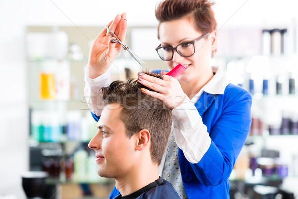 Hairdresser cutting man hair in barbershop Stock photo © Kzenon