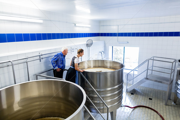Brewer and couple in beer brewery guided tour Stock photo © Kzenon