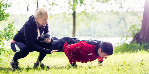 Sport couple outdoors with sling trainer Stock photo © Kzenon